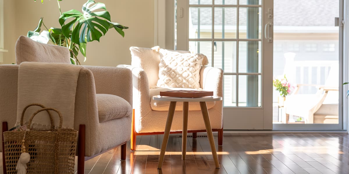 A cozy living room with natural light highlighting stylish furniture and newly completed hardwood floor installation, creating a warm and inviting space.