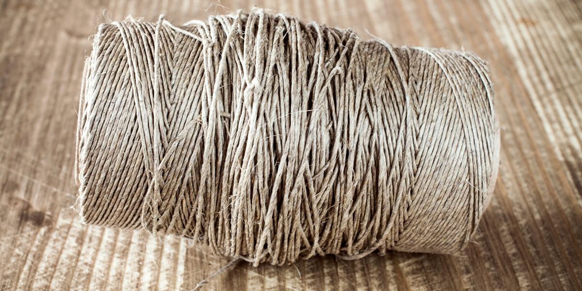 A spool of natural fiber being used to weave natural fiber carpet