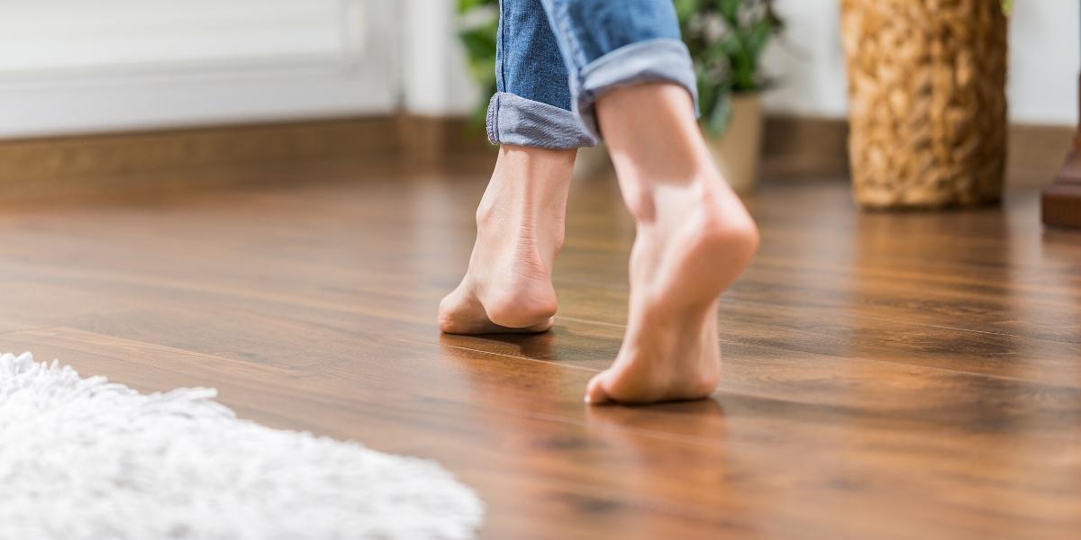 A woman walking barefoot on Brazilian walnut flooring, one of the best hardwood floors available