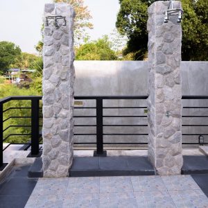 A dual outdoor shower with outdoor stone tile flooring