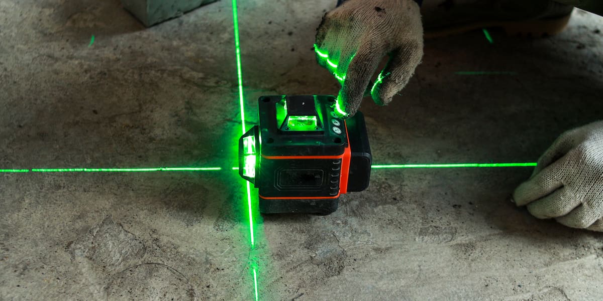 A contractor using a laser level on a rough surface, ensuring precision when leveling a concrete slab for a stable and even foundation.