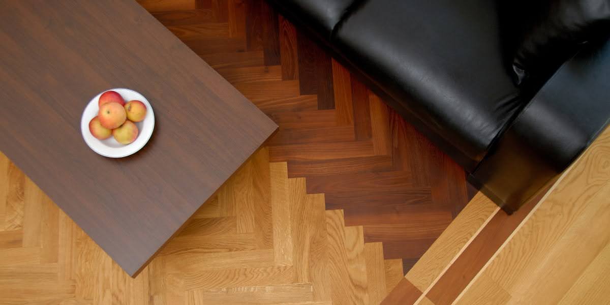 Overhead view of two different wood floors meeting with a clean transition between contrasting wood tones in a commercial interior