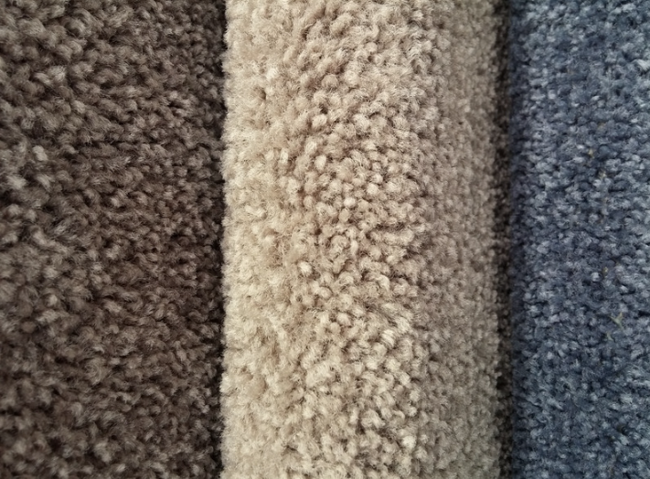 A variety of medium pile carpet lined up in a row.
