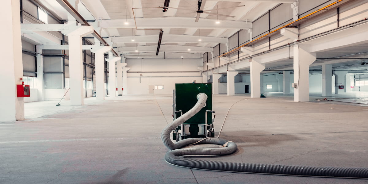 Industrial space showcasing commercial floor preparation process with specialized machinery, emphasizing the importance of a well-prepared surface for flooring installation.