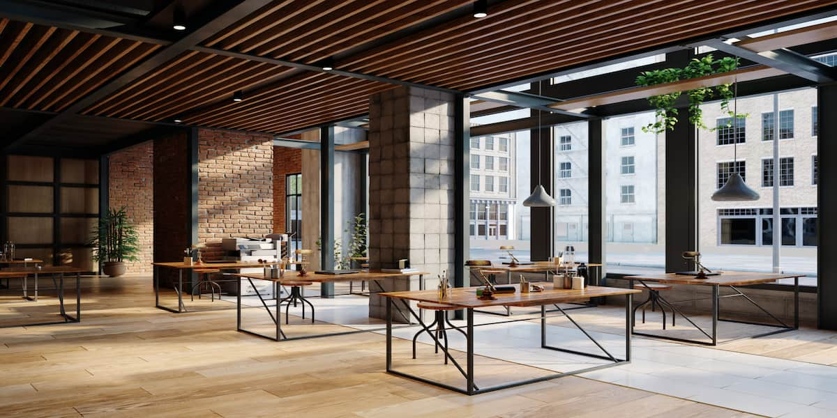 Modern industrial workspace with stylish office flooring featuring light-colored wood tiles, blending seamlessly with exposed brick walls, large windows, and contemporary wooden ceiling panels.