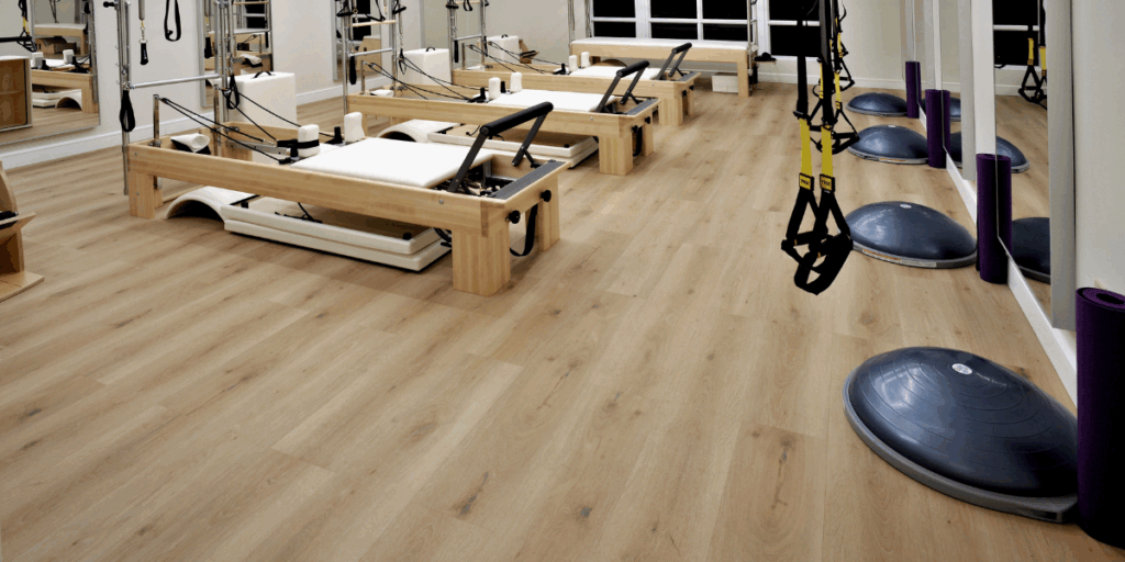 Commercial hardwood flooring installation in a fitness studio designed for pilates and low impact training equipment