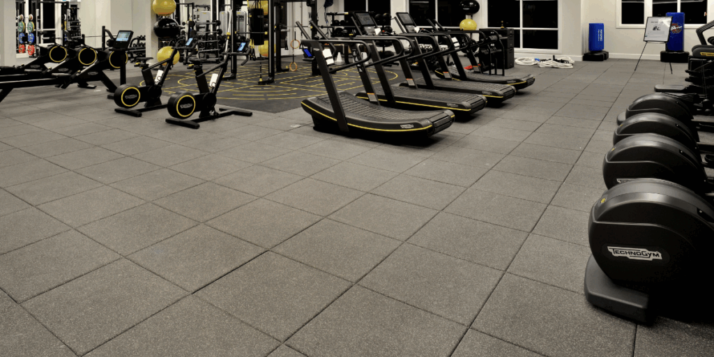 Commercial rubber flooring installation in a gym designed for treadmills, strength equipment, and high impact workout areas
