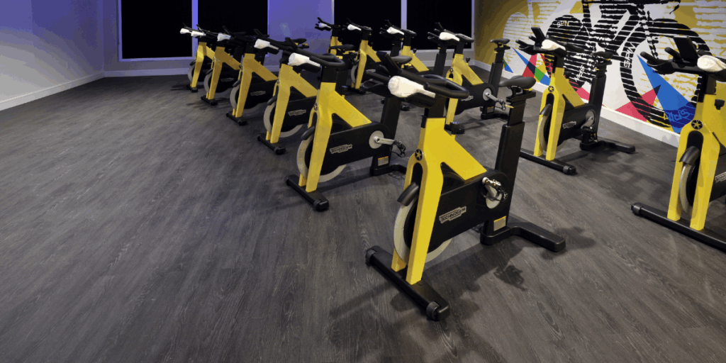 Commercial vinyl flooring installation in a fitness studio designed for stationary bikes and high traffic workout areas