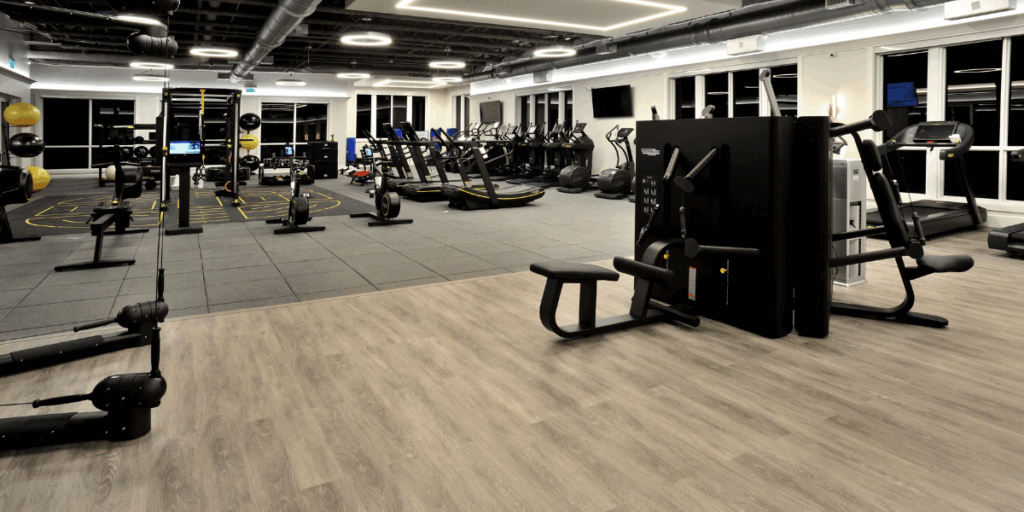 Commercial gym flooring with rubber tiles and wood look vinyl designed for fitness centers and training areas