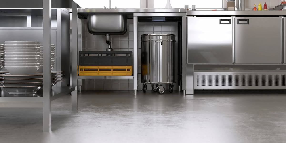 Commercial kitchen interior with stainless equipment and seamless epoxy flooring for restaurants designed for safety and easy cleaning